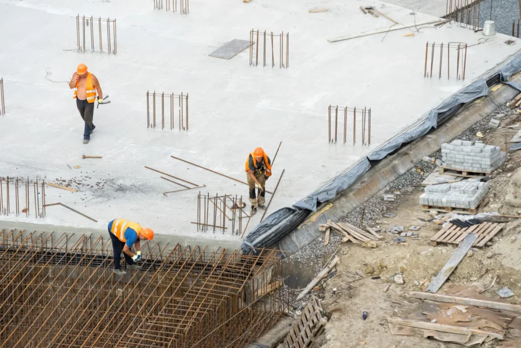 Workers building a concrete foundation with reinforcement